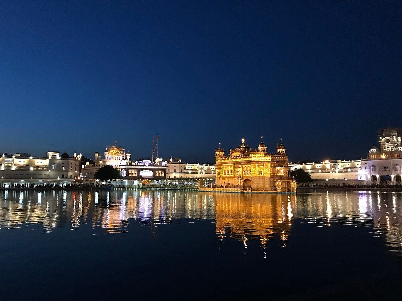 Golden Temple in Amritsar lit up at night and reflected in the water of the sarovar