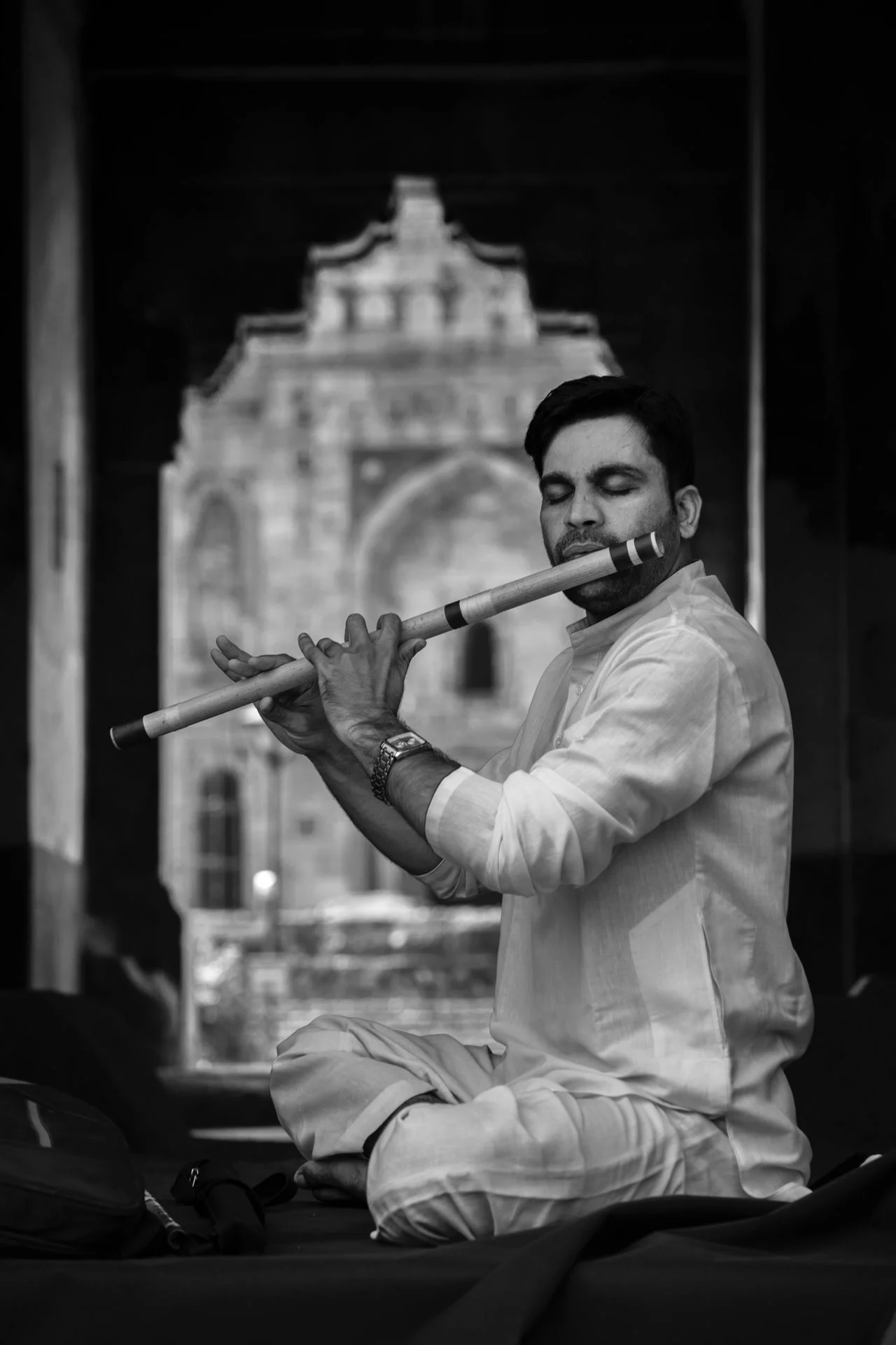 An Indian flute player holding a bansuri sideways
