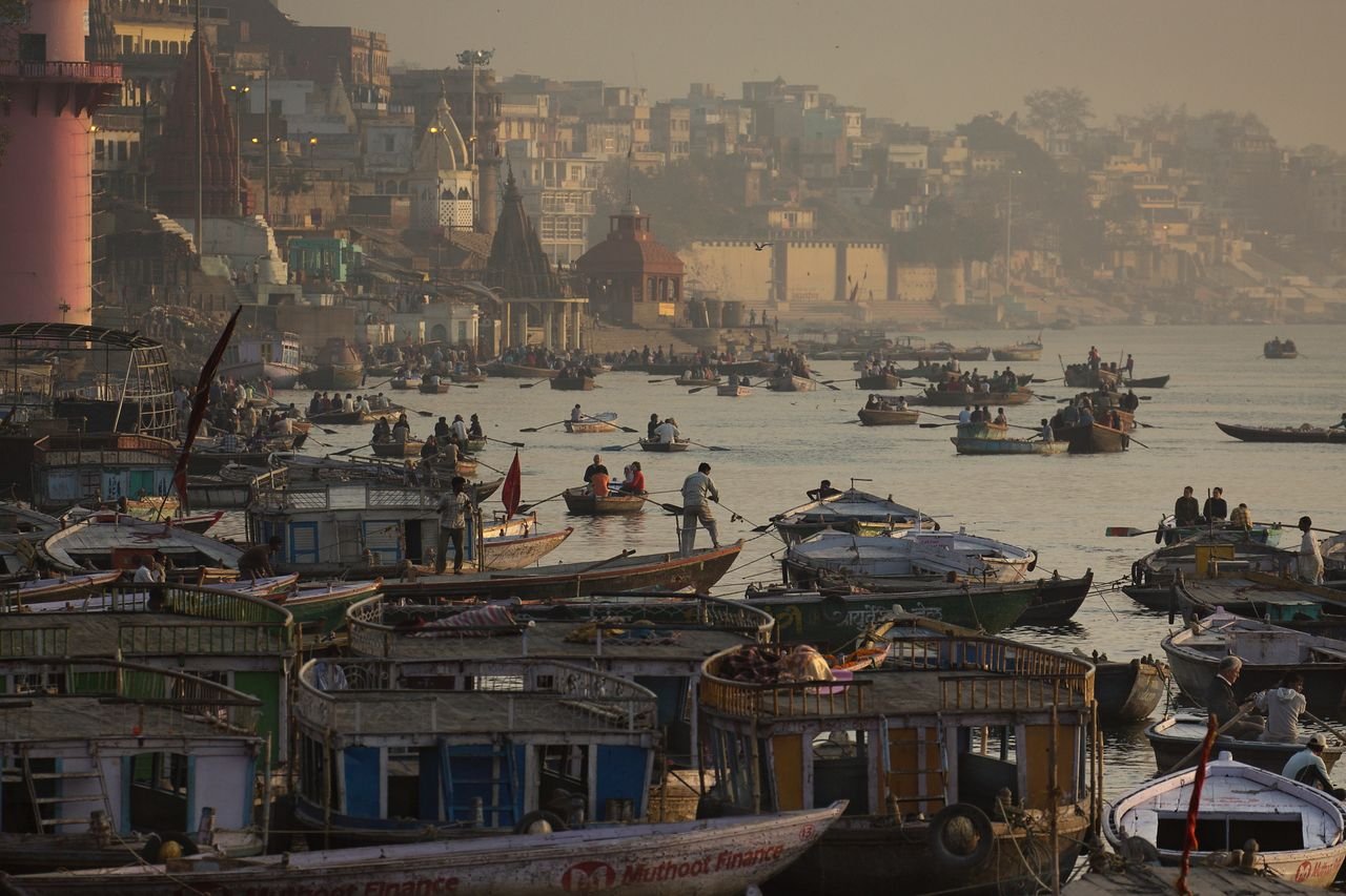 सुबह के समय वाराणसी का सिंधिया घाट, पानी के किनारे खड़े मंदिर